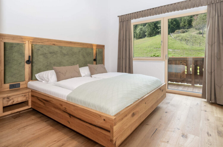 Schlafzimmer mit Balkon und Blick in die Natur