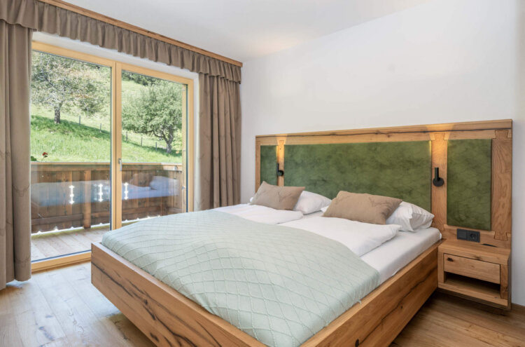 Schlafzimmer mit Balkon und Ausblick in die Natur